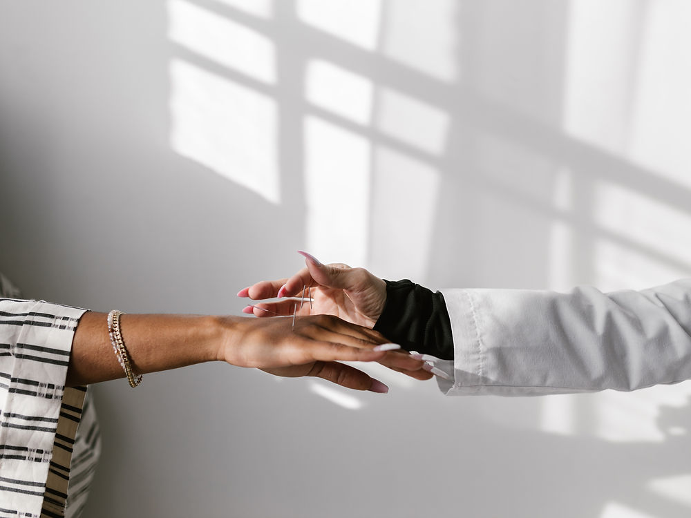 Betreuerin hält behutsam die Hand einer Patientin